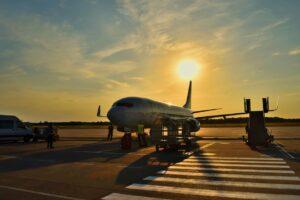 a small commercial passenger jet parked on an airport runway surrounded by airport employees