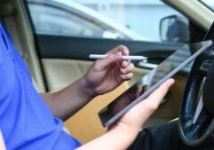 a delivery driver using a tablet while sitting inside their vehicle