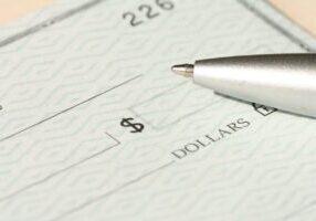 a ballpoint pen lying on a blank bank check
