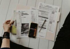 Hand and Folder of Tax documents and calculator